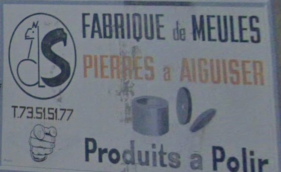 The full hand-painted sign — Fabrique de Meules, Pierres a Aiguiser, Produits a Polir — with the squirrel emblem